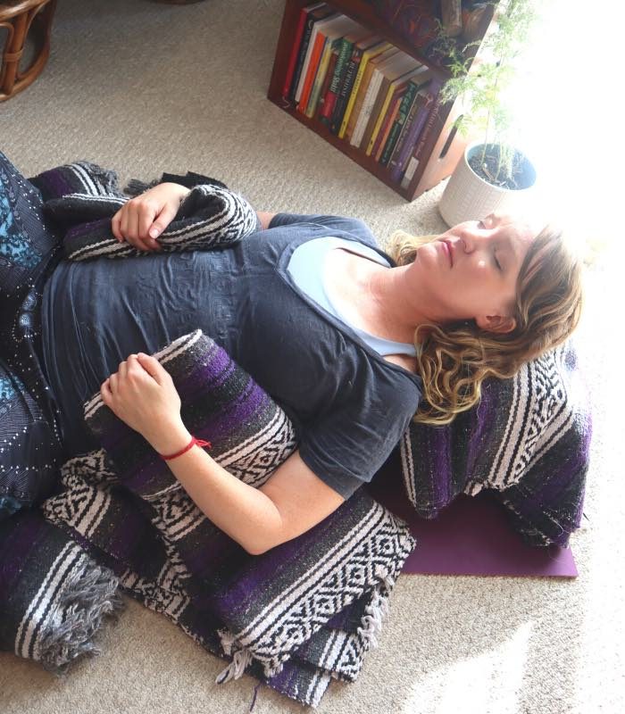 restorative yoga pose baddha konasana supported with bolster and blankets