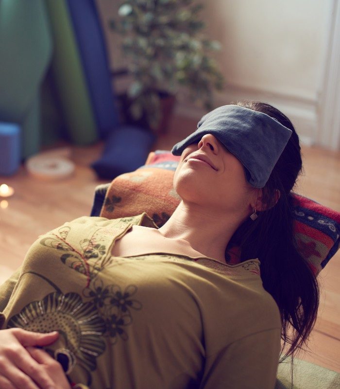 what is restorative yoga with lady in restorative yoga pose with eye pillow