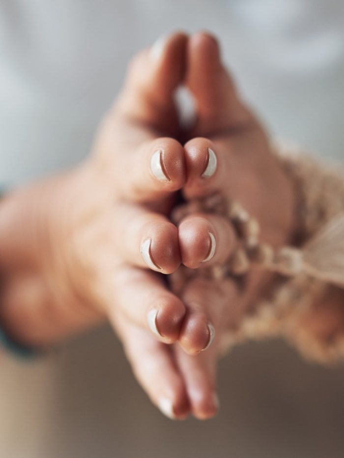 Yoga teacher trainings mala beads and hands in prayer