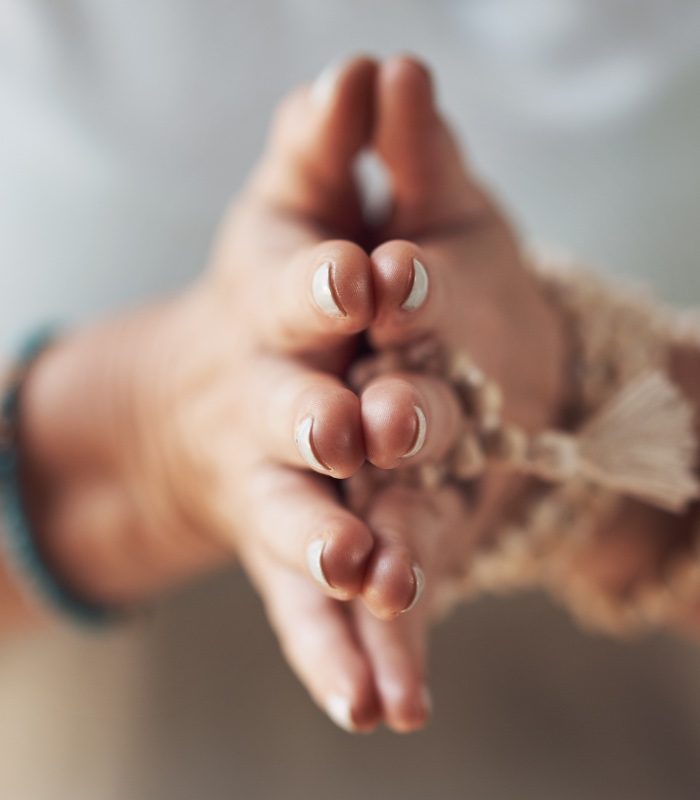Shanine Dennill Yoga Teacher Training palms together in prayer with mala bead